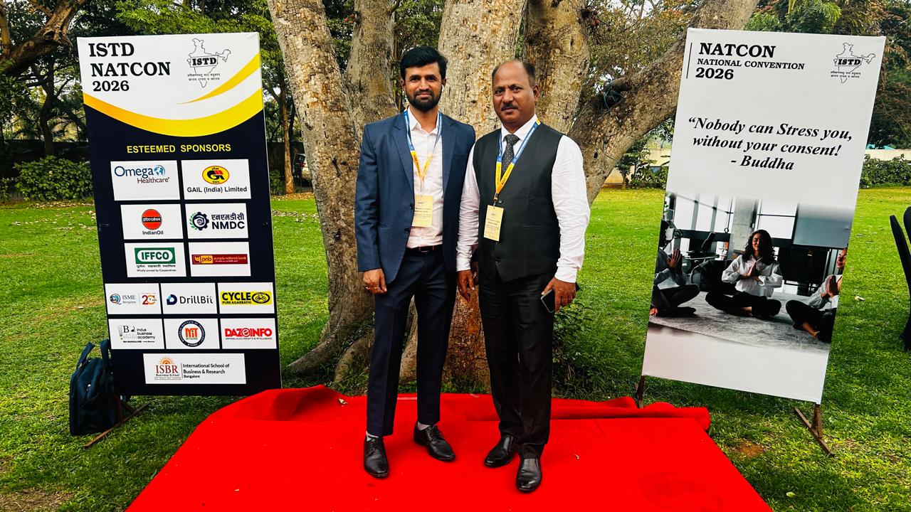 DrillBit representatives with NATCON 2026 sponsor board
